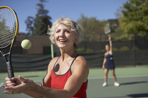 Caucasian women playing tennis on court