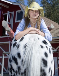 Mixed race girl laying on horse on ranch