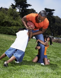 Father and children playing in park