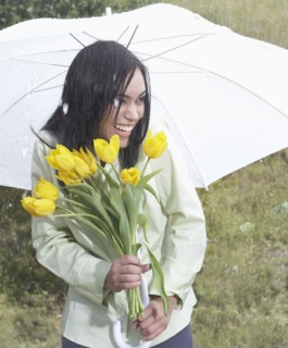 Indian woman carrying flowers in heavy rain