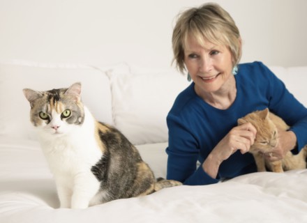 Senior Caucasian woman petting cats on bed