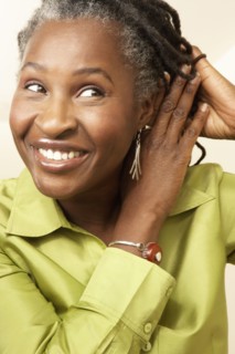 Senior mixed race woman tying up dreadlocks