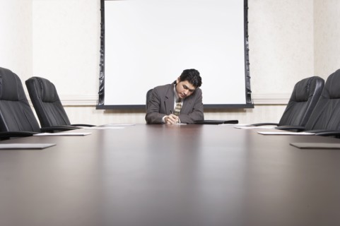 Mixed race businessman sitting at conference table