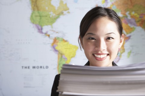 Chinese businesswoman standing by world map