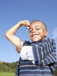 African American boy flexing his muscles