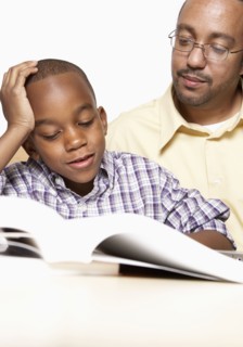 African American father helping son with homework