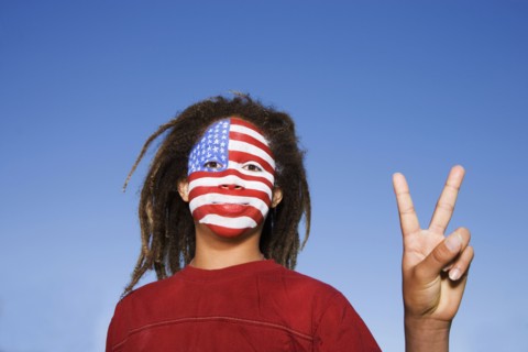 Mixed race boy with American flag painted on face