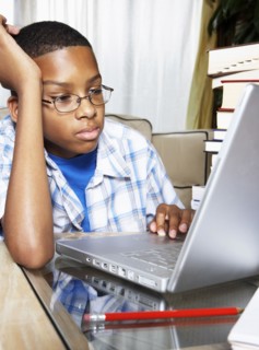 Mixed race boy using laptop