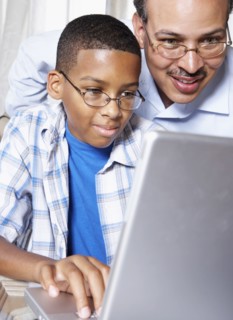 Father and son using laptop together
