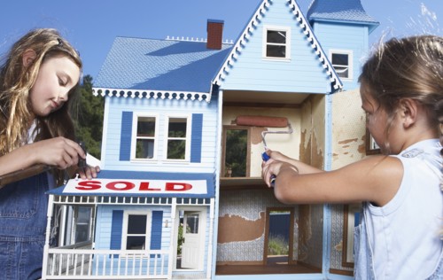 Mixed race girls fixing up doll house for sale