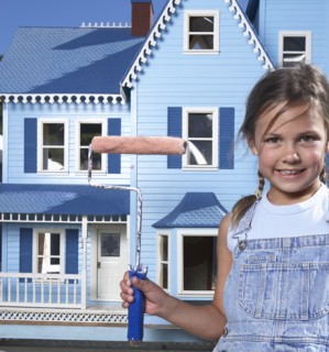 Mixed race girl painting doll house