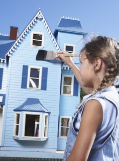 Mixed race girl painting doll house