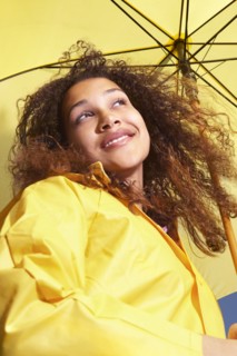 Mixed race woman standing under umbrella