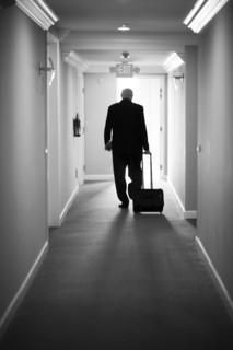 Caucasian businessman pulling luggage in hotel hallway