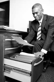 African American businessman putting paperwork in drawer