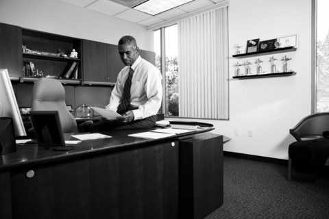 African American businessman sitting on desk