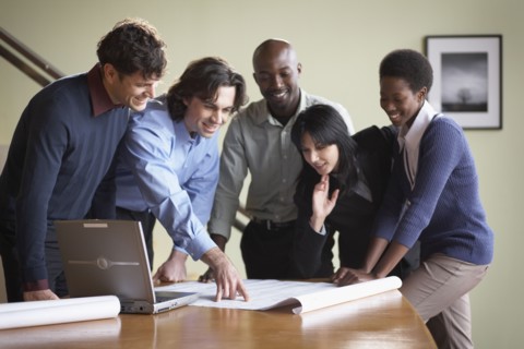 Multi-ethnic businesspeople looking at blueprints