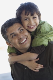 Hispanic boy hugging father