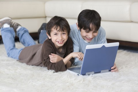 Hispanic brothers looking at laptop