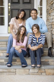 Hispanic family sitting on porch steps