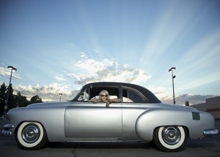 Woman with tattoos leaning out window of 1951 Chevy