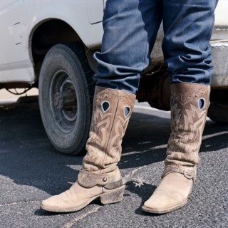 Close up of man wearing cowboy boots with spurs
