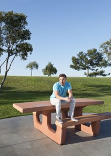 Caucasian man sitting on picnic table in park