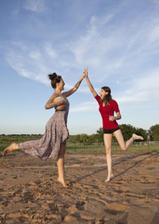 Caucasian women high fiving in rural field
