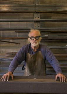 Portrait of serious Caucasian blacksmith in workshop