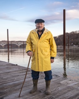 Older Caucasian fisherman standing on dock