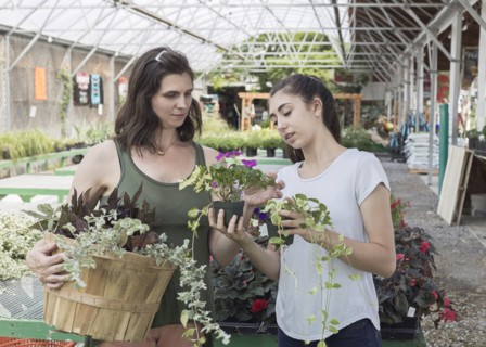Caucasian mother and daughter shopping for flowers