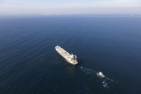 Oil tanker with tugboat at sea