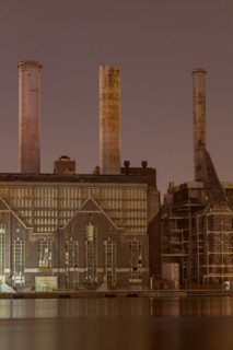 Factory smokestacks lit up at night