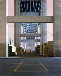 Pile of lumber under bridge