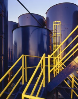 Yellow banisters on staircase near blue storage tanks