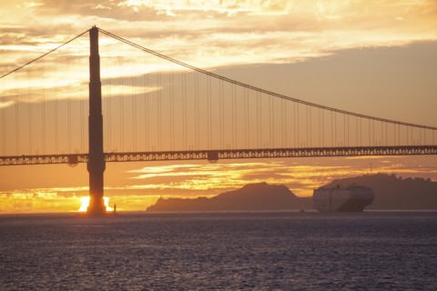 Silhouette of bridge over water at sunset