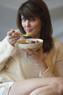 Caucasian woman eating bowl of fruit