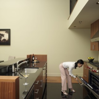 Asian woman looking in oven