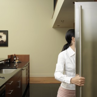 Asian woman looking in refrigerator