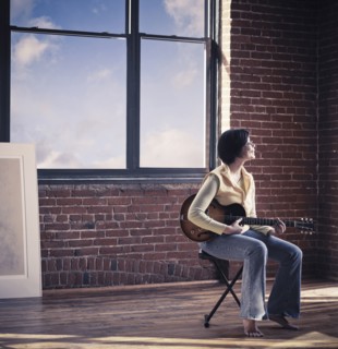 Caucasian woman playing guitar in living room