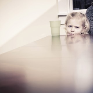 Caucasian girl peering over table
