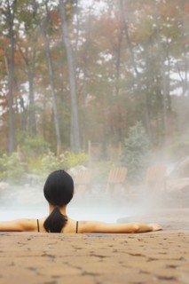 Rear view of woman sitting in hot tub