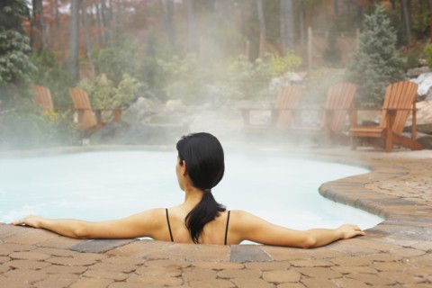 Rear view of woman sitting in hot tub