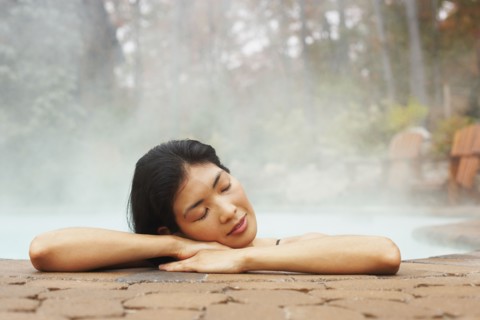 Asian woman sitting in hot tub