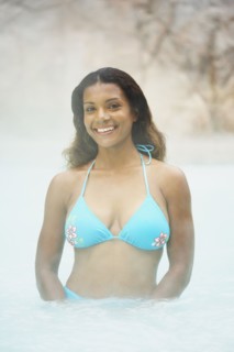 African woman standing in hot tub