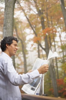 Man reading newspaper outdoors