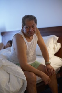 Man in bedroom waking up in the morning