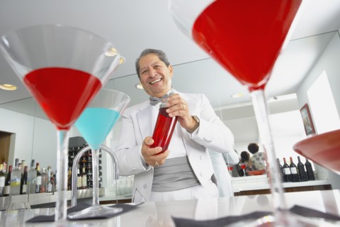 Hispanic host mixing martini cocktails at party