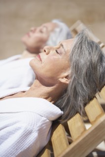 Friends sleeping on lounge chairs at resort