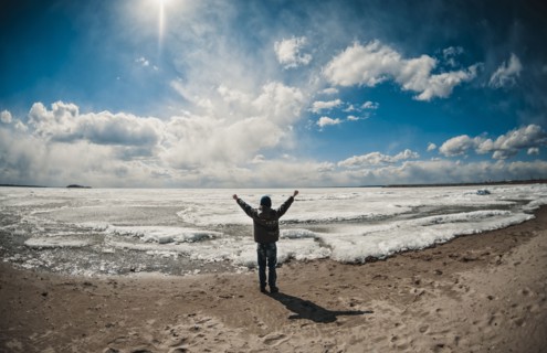 Caucasian boy cheering on ocean beach